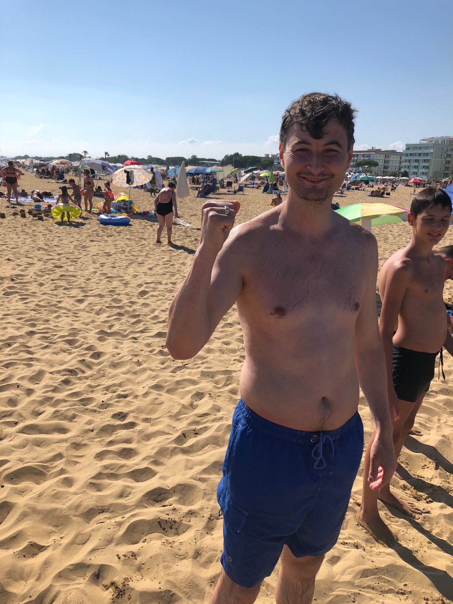 Lächelnder Mann am Strand von Bibione mit dem wiedergefundenen Ring am Finger
